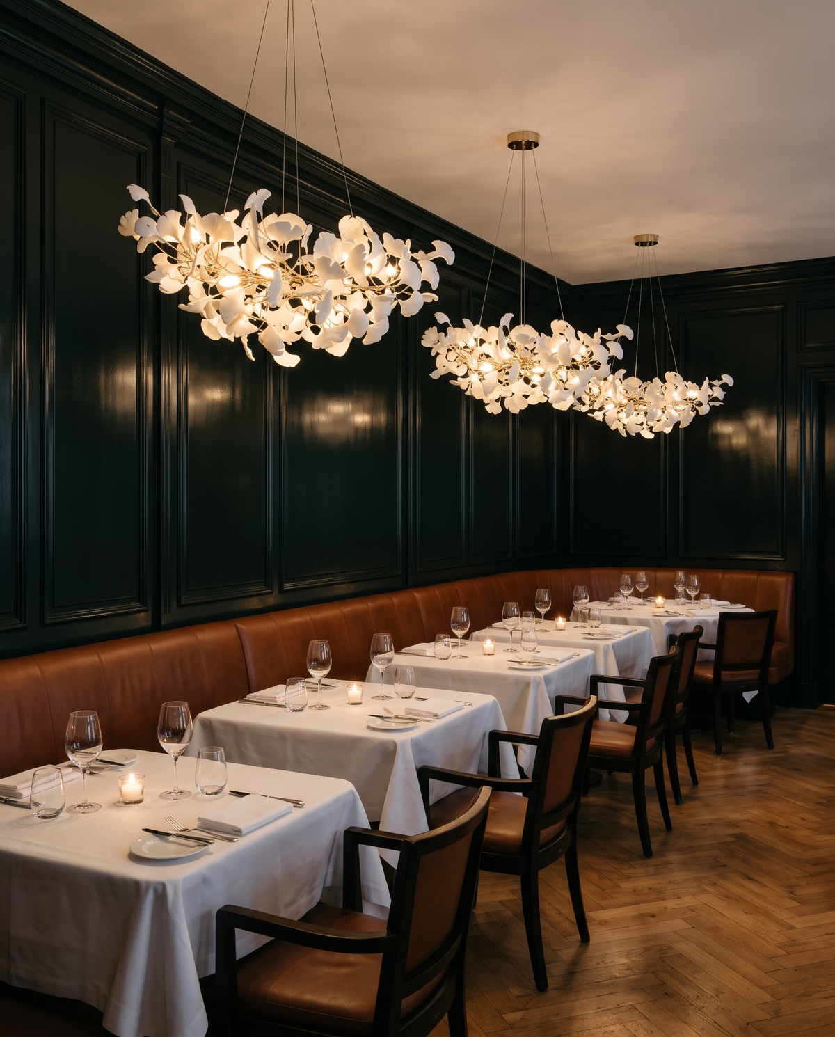Three Maidenhair chandeliers in Gilt above banquette tables in a Mayfair restaurant