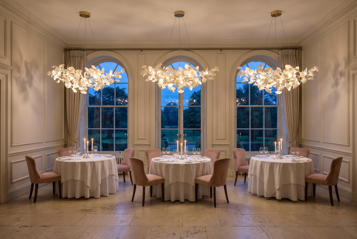 Three Maidenhair chandeliers in Gilt over round tables in a country house hotel restaurant at dusk