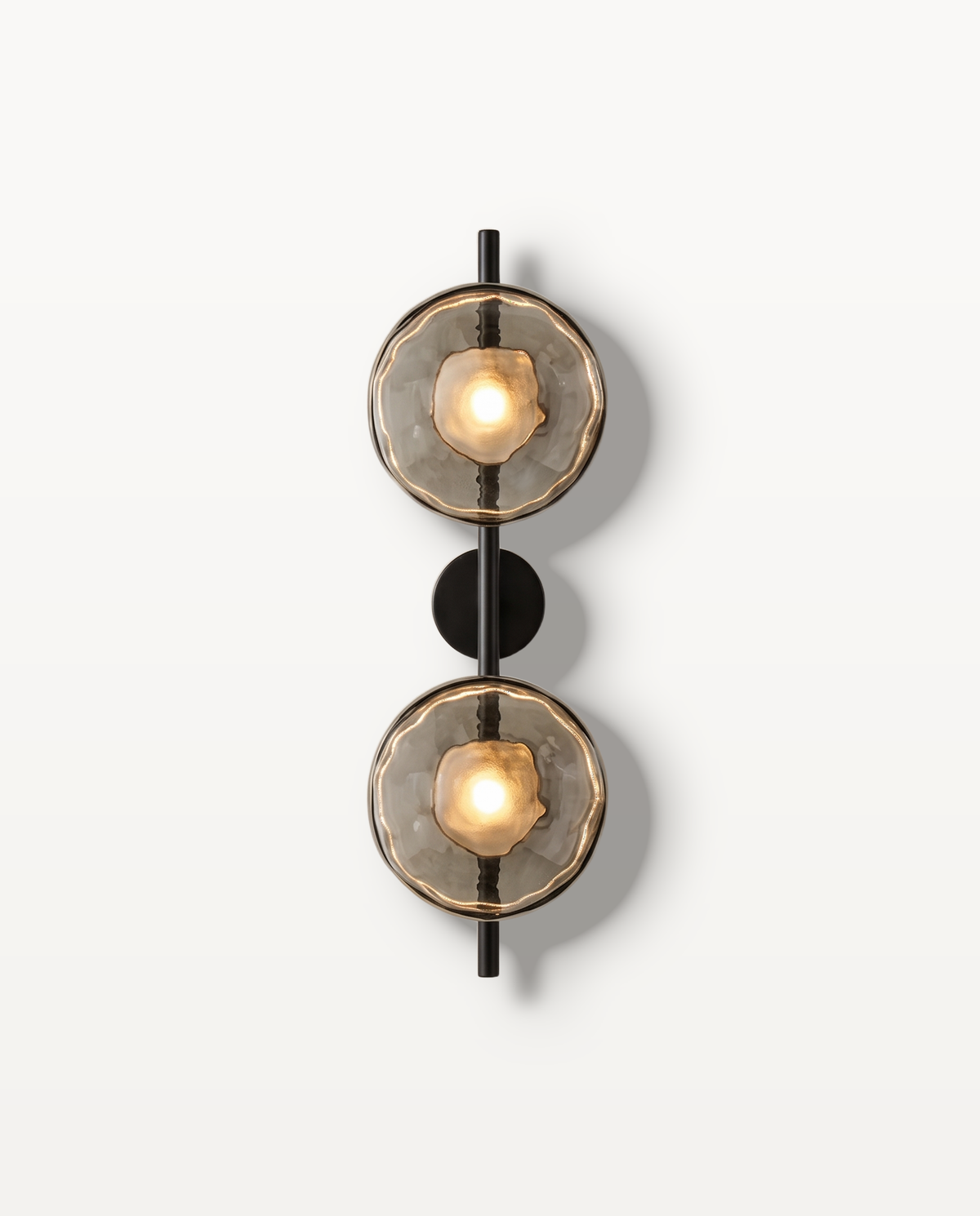 The Monocle Wall Light, two rippled Smoke glass discs on a Jet stem, lit