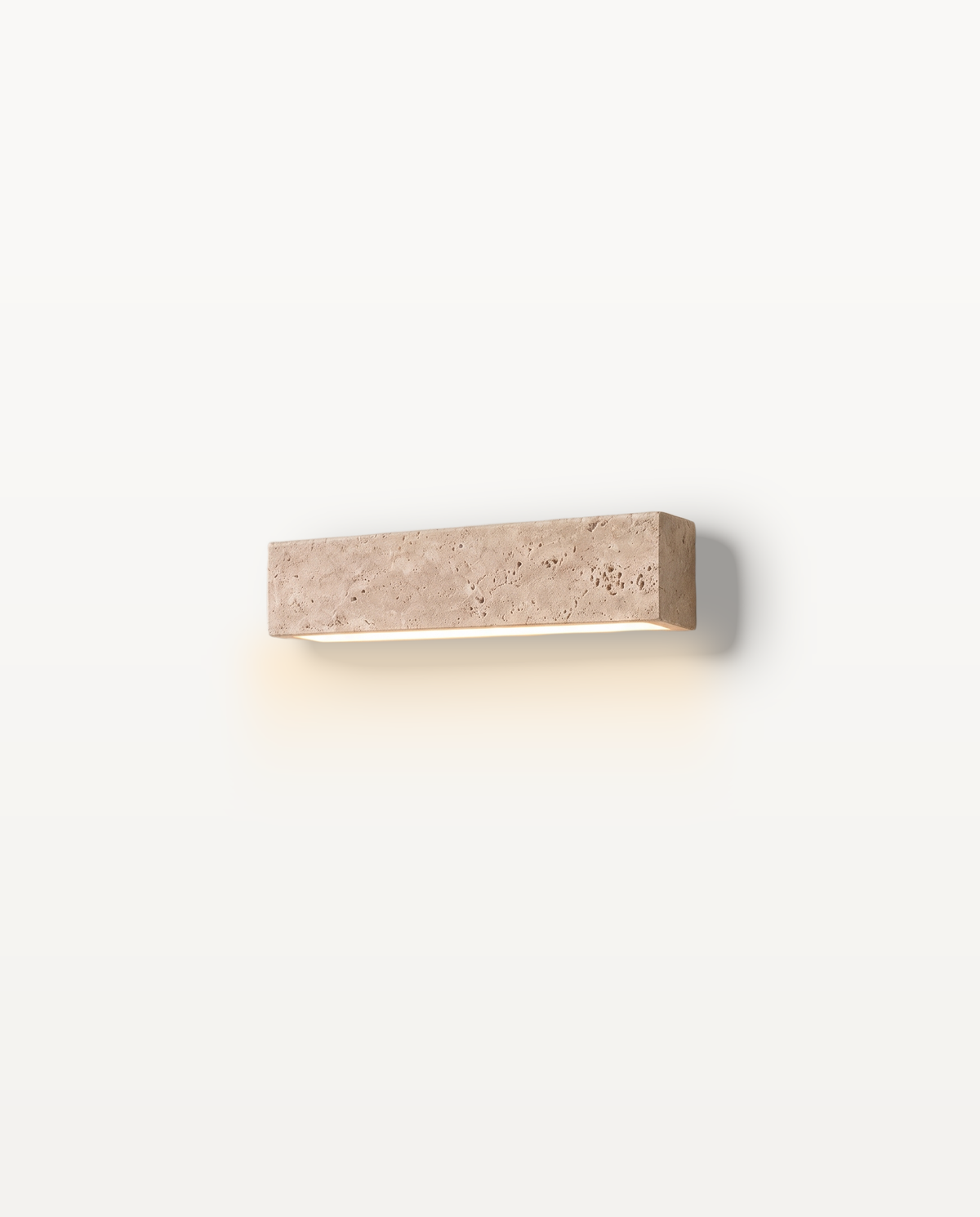 The Monolith Wall Light – 24 cm, a block of natural travertine with a soft wash of light beneath