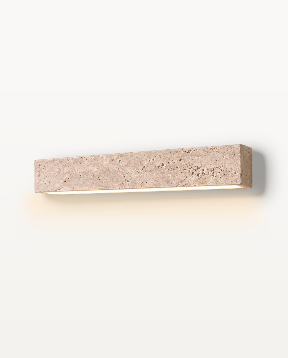 The Monolith Wall Light – 42 cm, a long bar of natural travertine with a soft wash of light beneath
