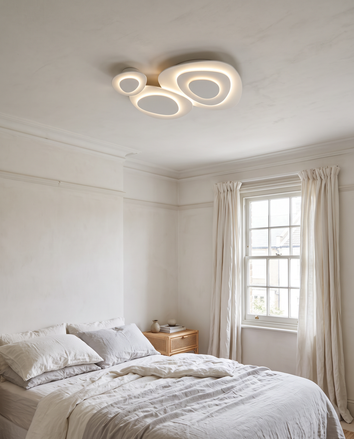 The Nimbus cloud ceiling light above a bed in a calm white bedroom