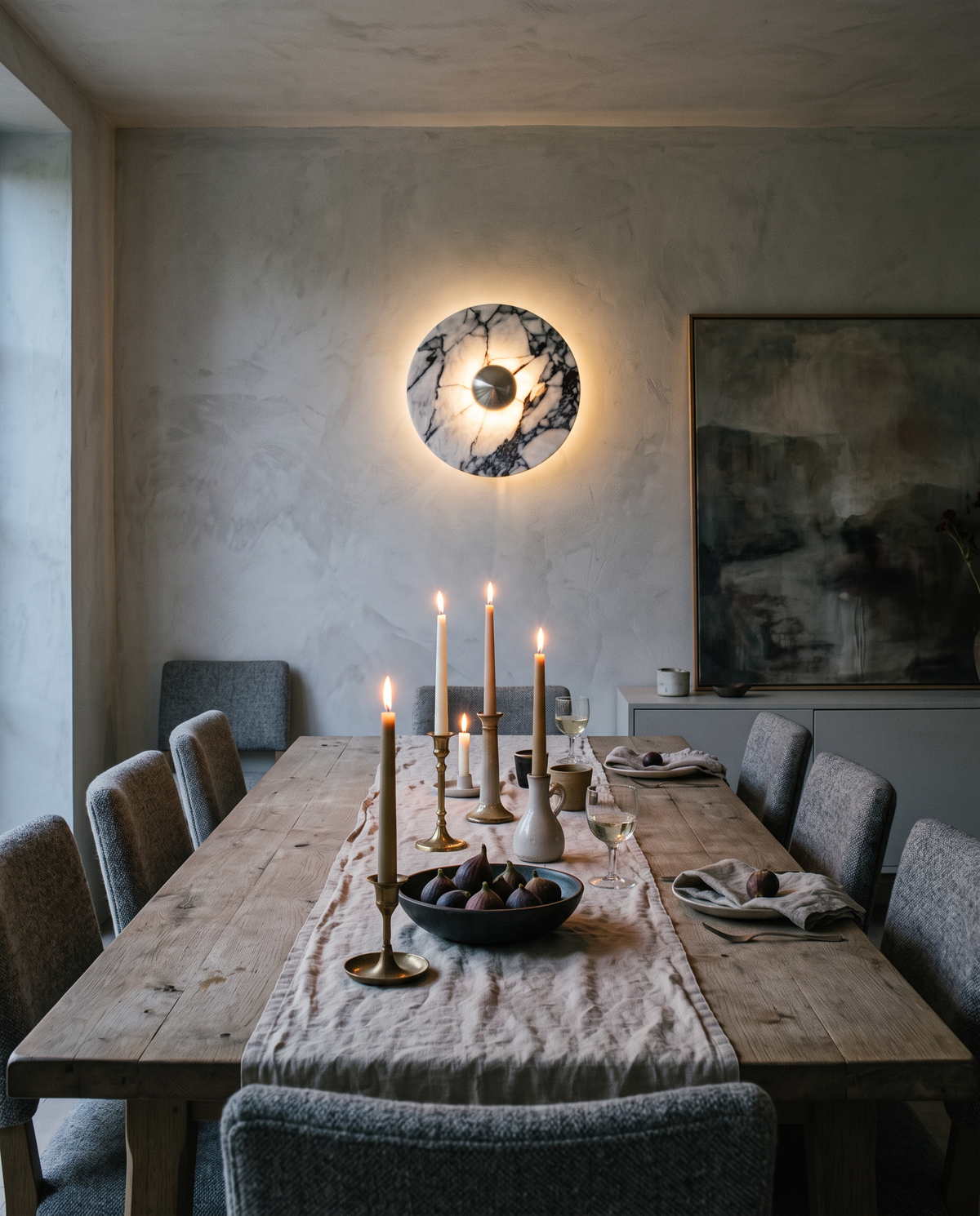 The Orb marble wall light in silver at the end of an oak dining table