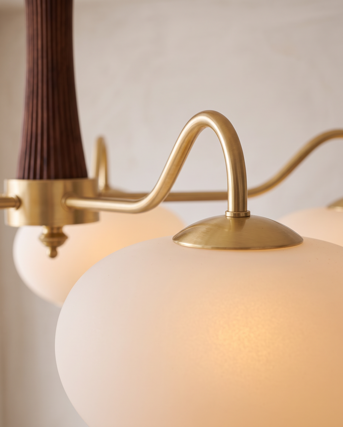 Close-up of a brass arm and opal glass shade of The Orchard