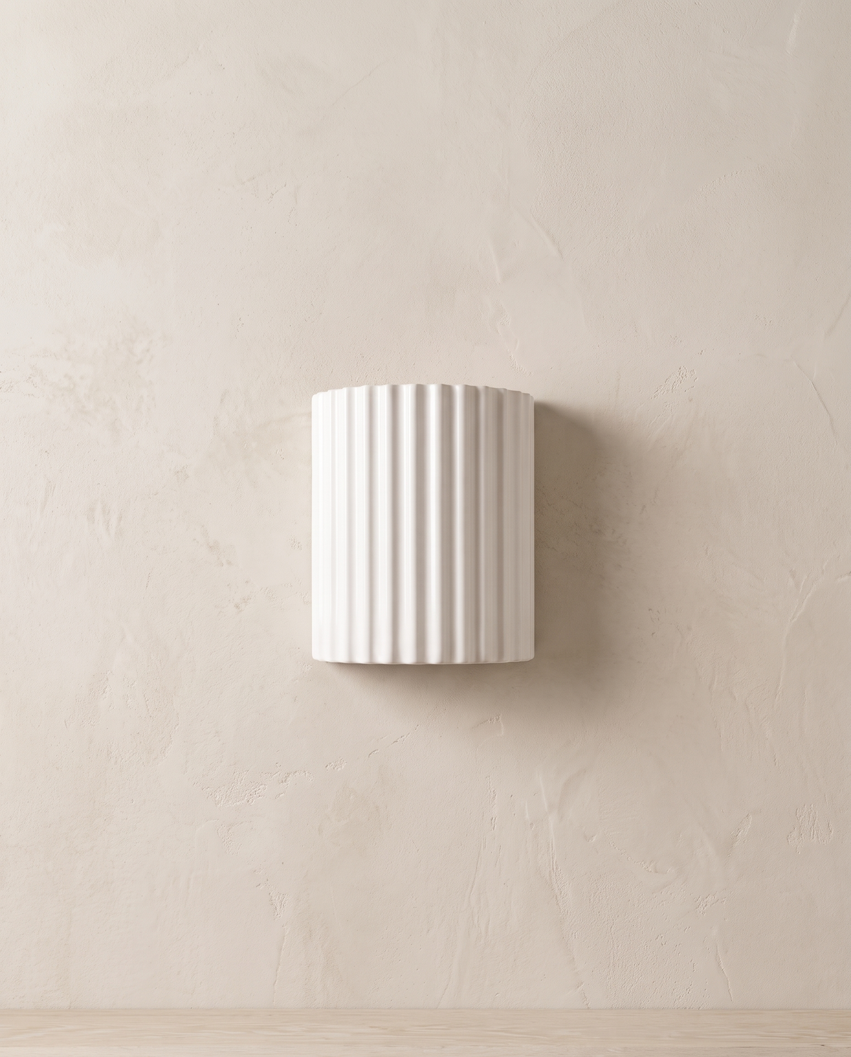 The Pleat, white fluted wall light in situ on lime-washed plaster wall — Selden Home product photography