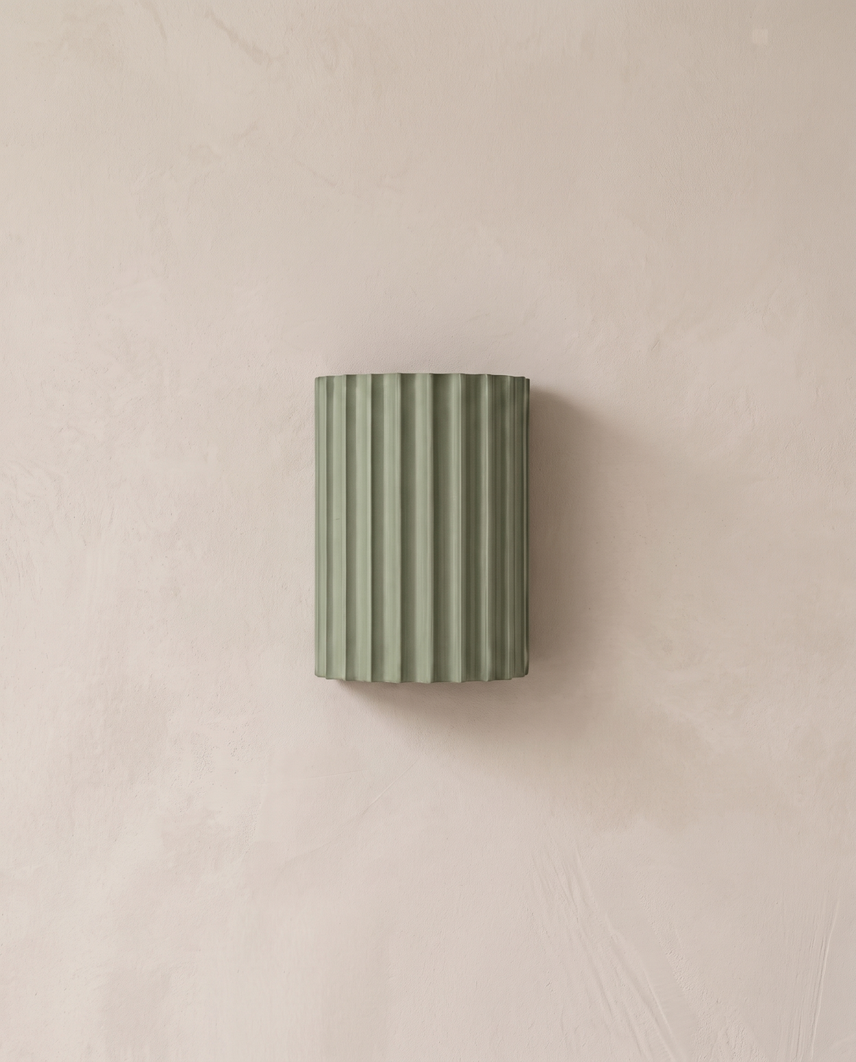 The Pleat, green fluted wall light in situ on lime-washed plaster wall — Selden Home product photography