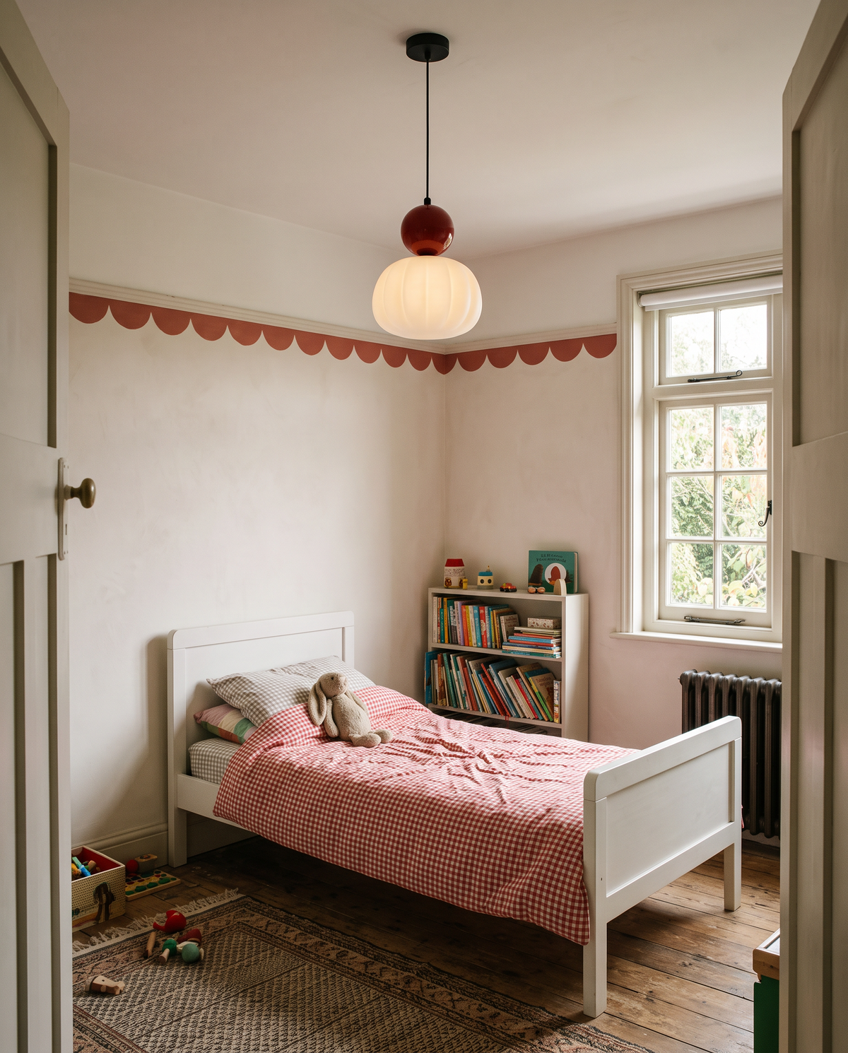 A Pomander pendant in Cherry in a child's bedroom with a gingham quilt