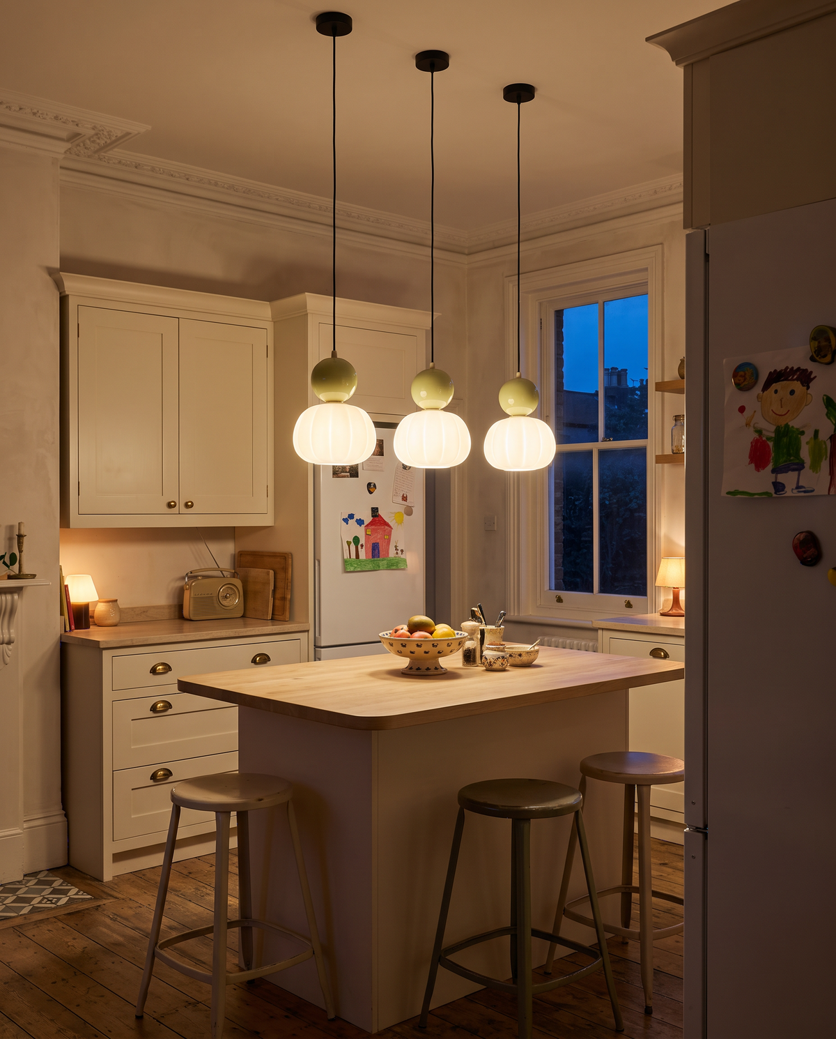 Three Pomander pendants in Pistachio over a family kitchen island