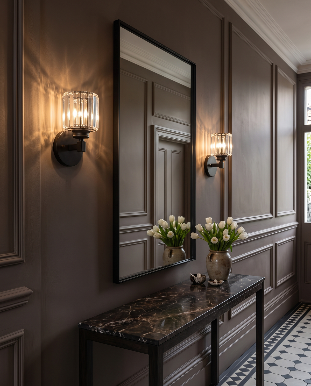A pair of Prism crystal wall sconces in black either side of a hallway mirror