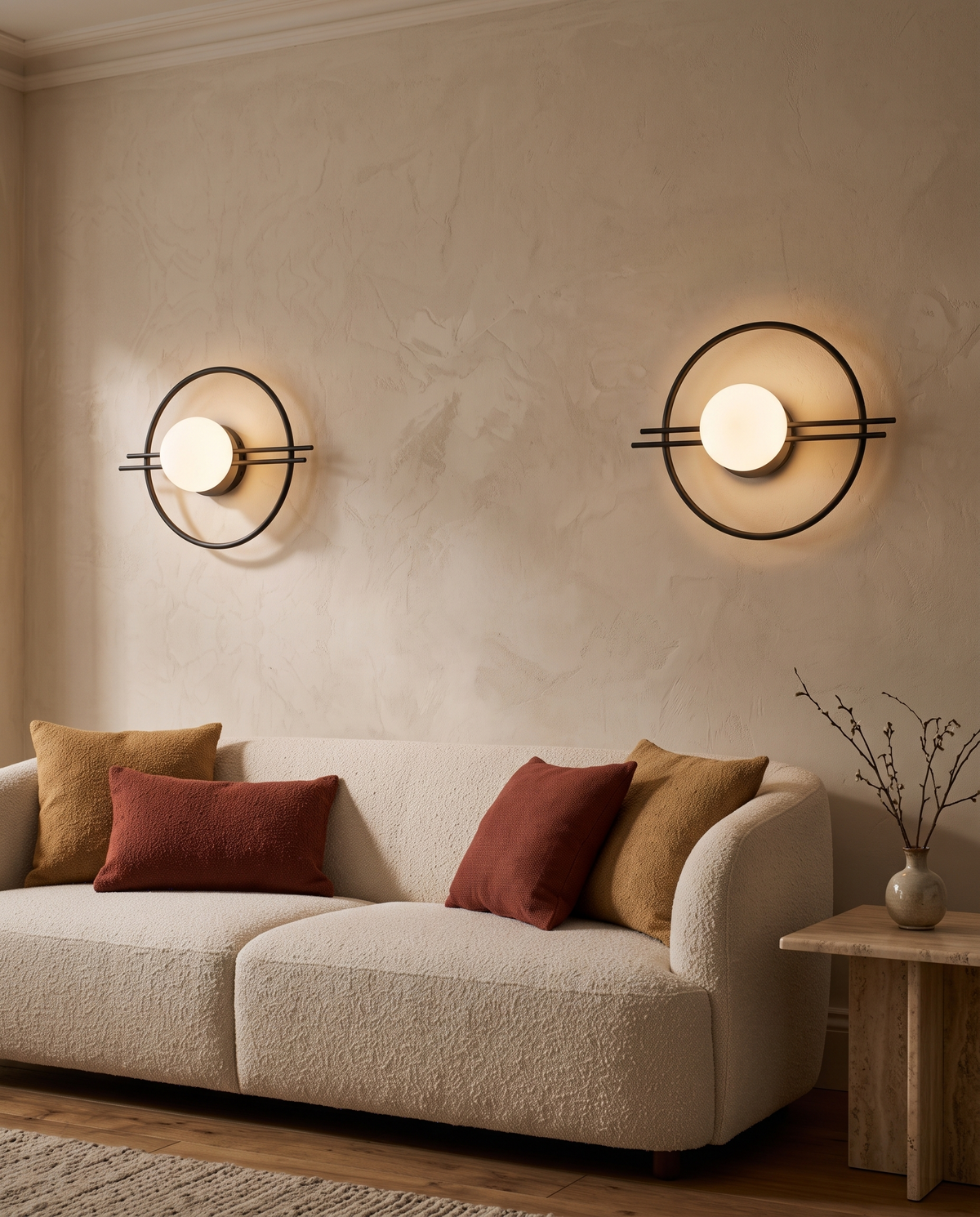 A pair of Ring globe wall sconces in black above a cream boucle sofa