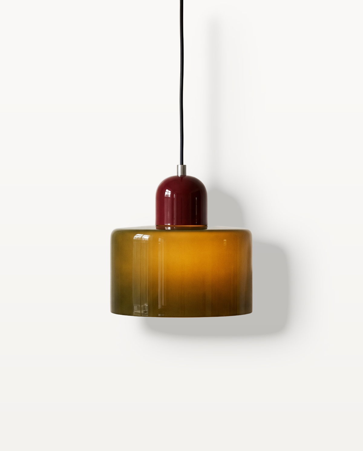 The Sherbet Pendant in Olive & Claret, an olive glass cylinder under a claret cap, lit