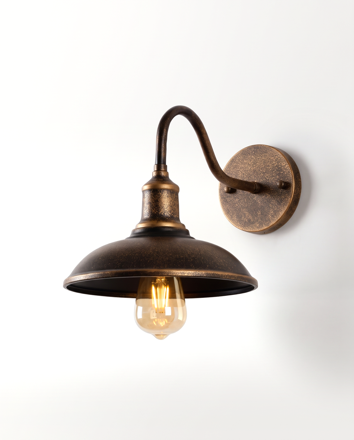 The Stable Outdoor Wall Light, Classic Arm, an aged bronze swan-neck barn light, lit
