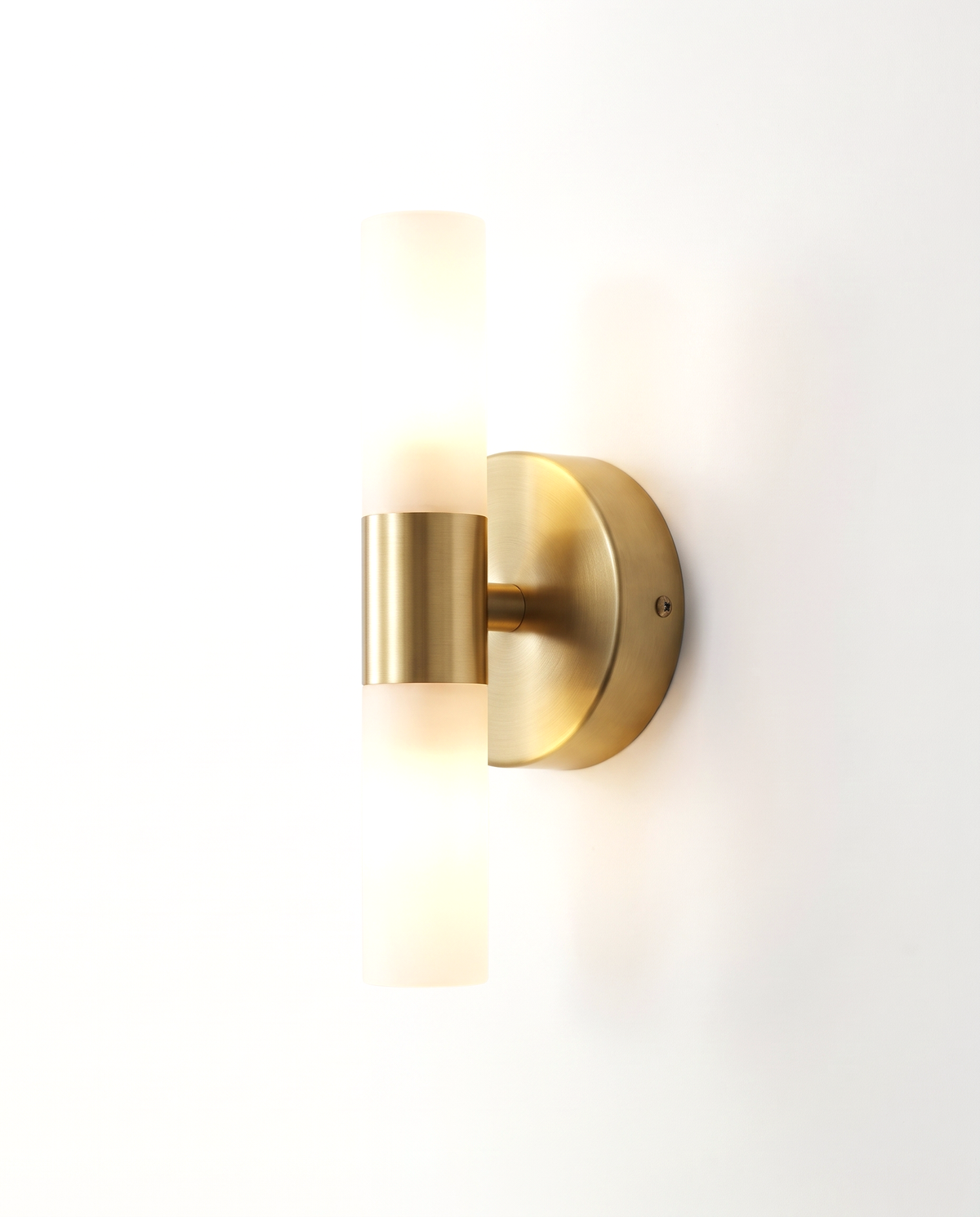 The Washstand Wall Light, Up & Down style, brushed brass with a frosted tube, lit