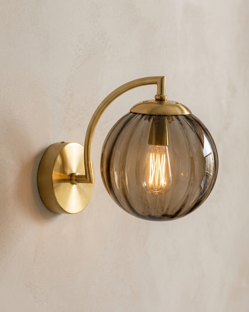 The Bloom, ribbed glass wall sconce, coffee glass on gold arm, mounted on plaster wall — Selden Home product photography