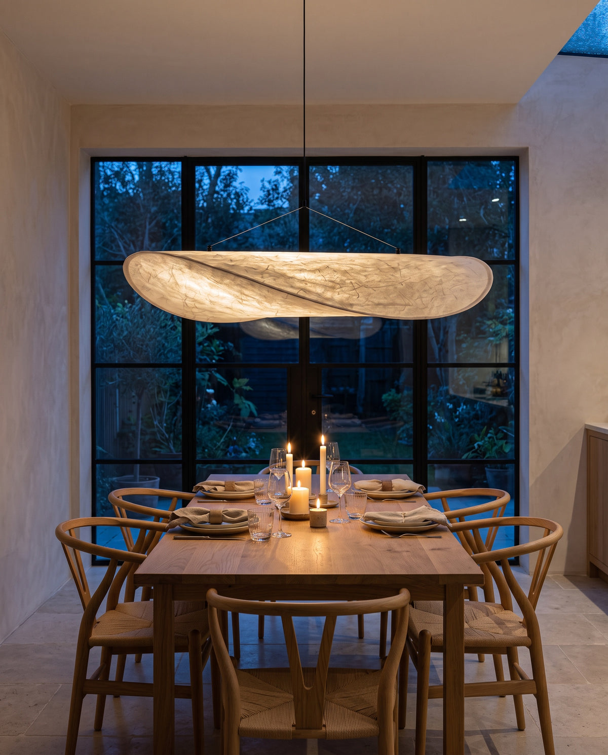The Drift over an oak dining table in a London kitchen extension at dusk