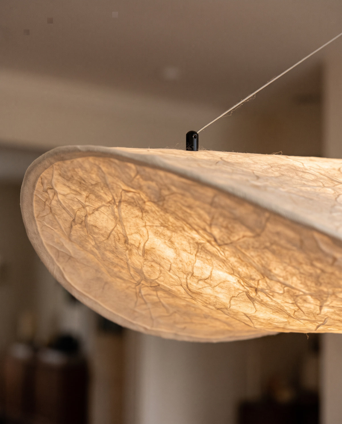 Close-up of the twisted end and creased paper of The Drift, lit