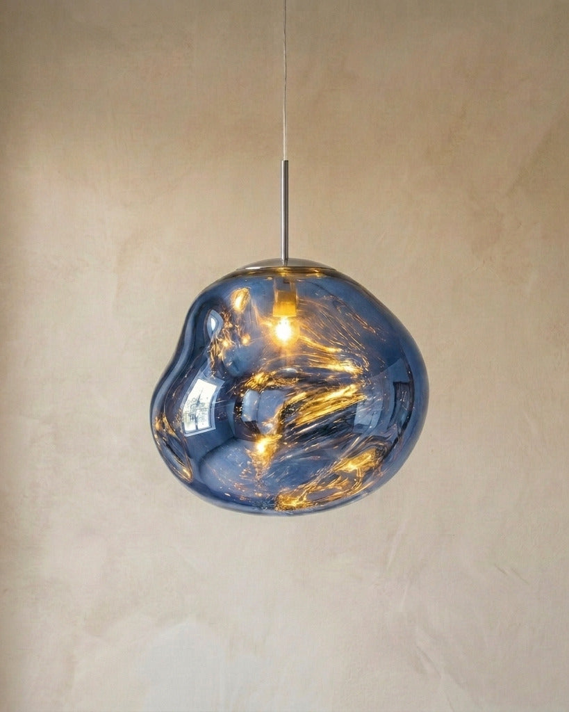 The Ember blue molten acrylic pendant light with chrome fittings, lit, in front of a lime-washed plaster wall — Selden Home product photography