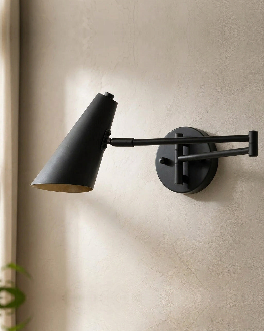 The Pivot, black industrial swing arm wall light with cone shade, mounted on plaster wall — Selden Home product photography