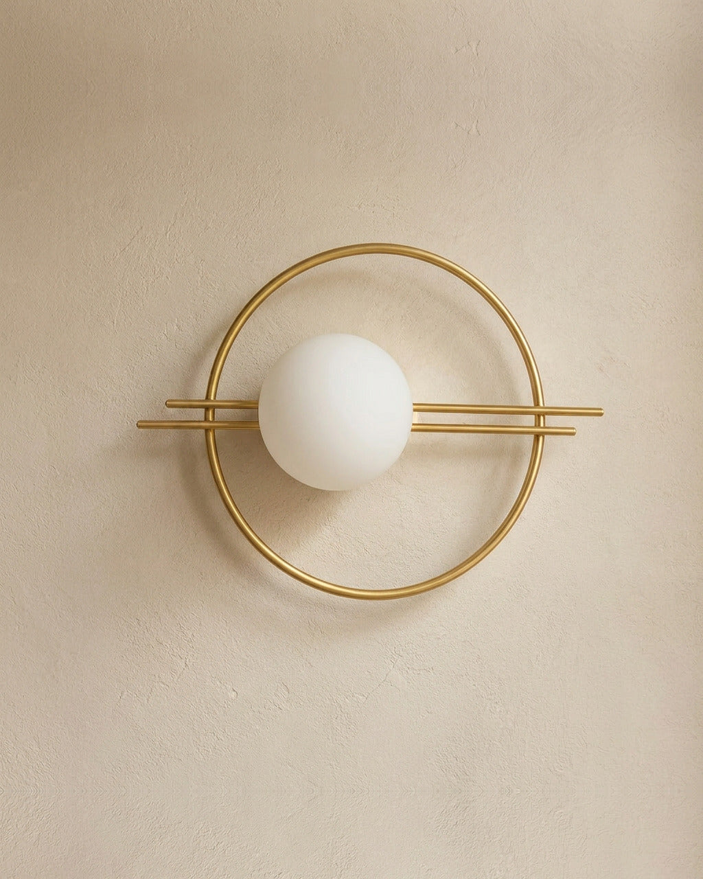 The Ring, gold iron wall sconce with frosted opal glass globe, mounted on plaster wall — Selden Home product photography