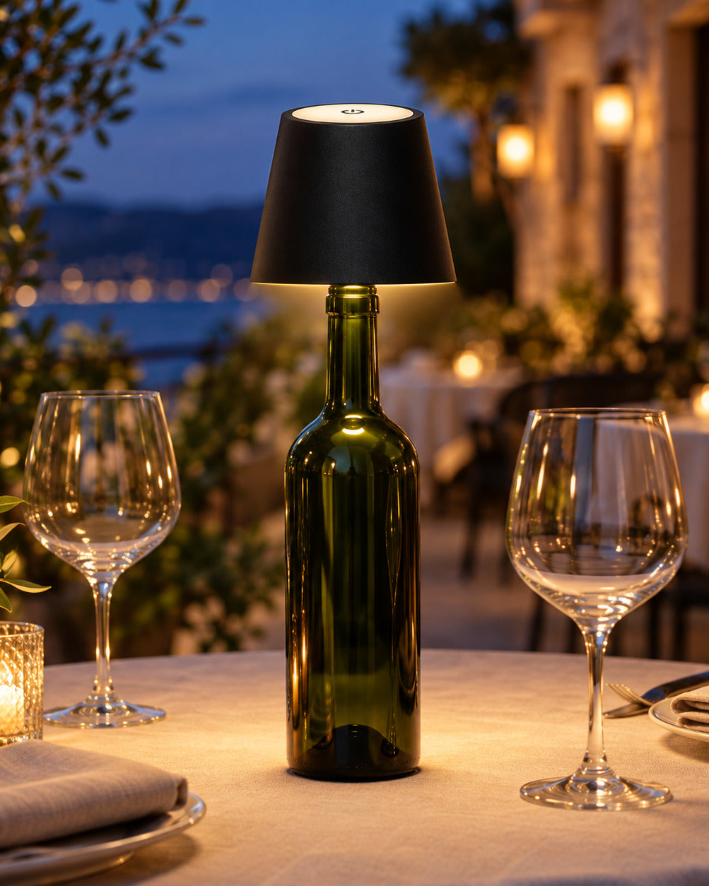 The Vesper in Jet on a green wine bottle, lighting a dinner table at night